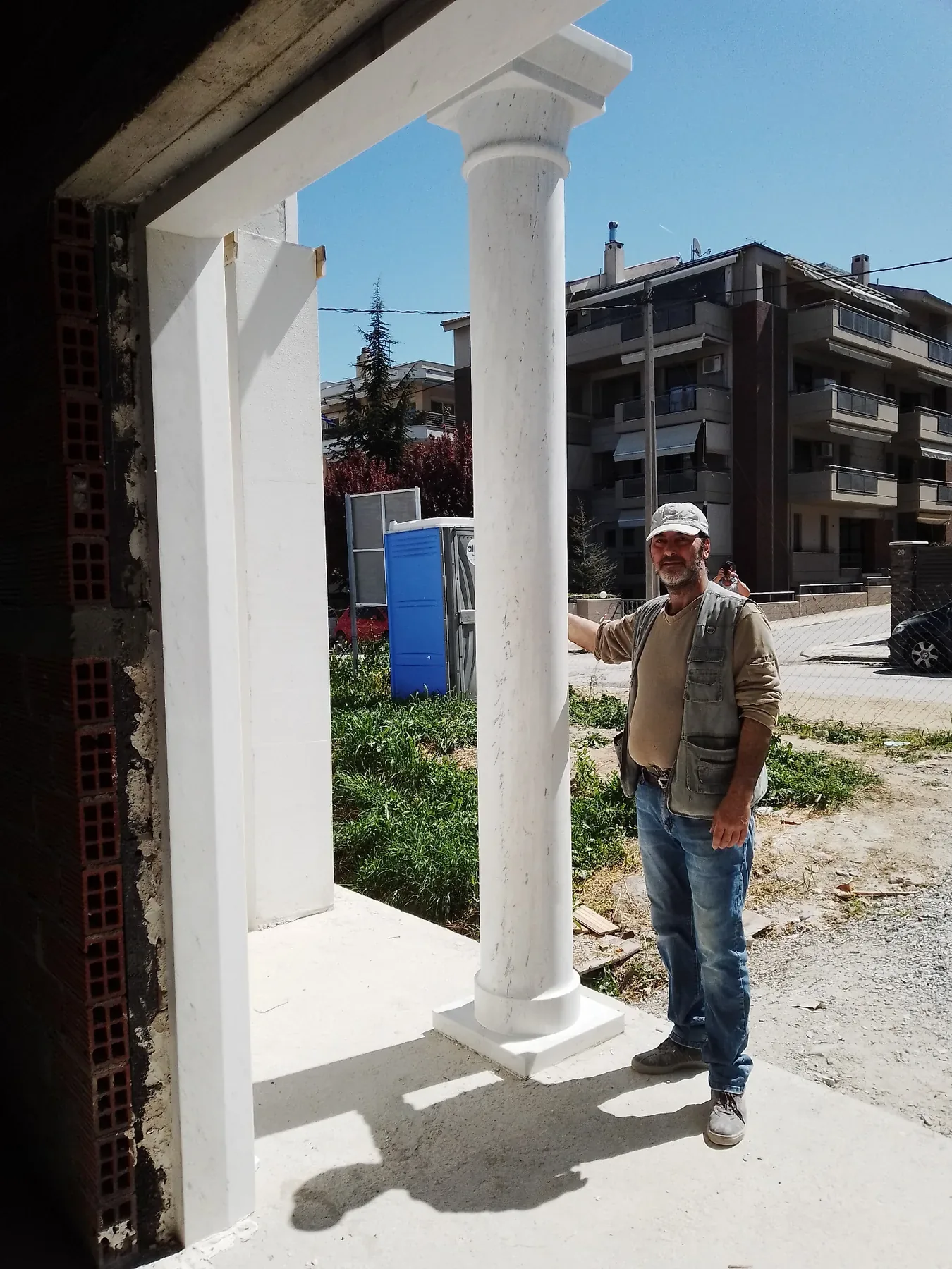 Ο δημιουργός δίπλα σε μαρμάρινο κίονα σε εξωτερική κατασκευή